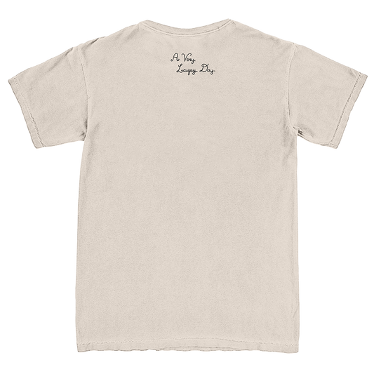 A light beige crewneck t-shirt shown from the back, featuring the text 'A Very Long Day' printed in a small black cursive font near the upper center back.