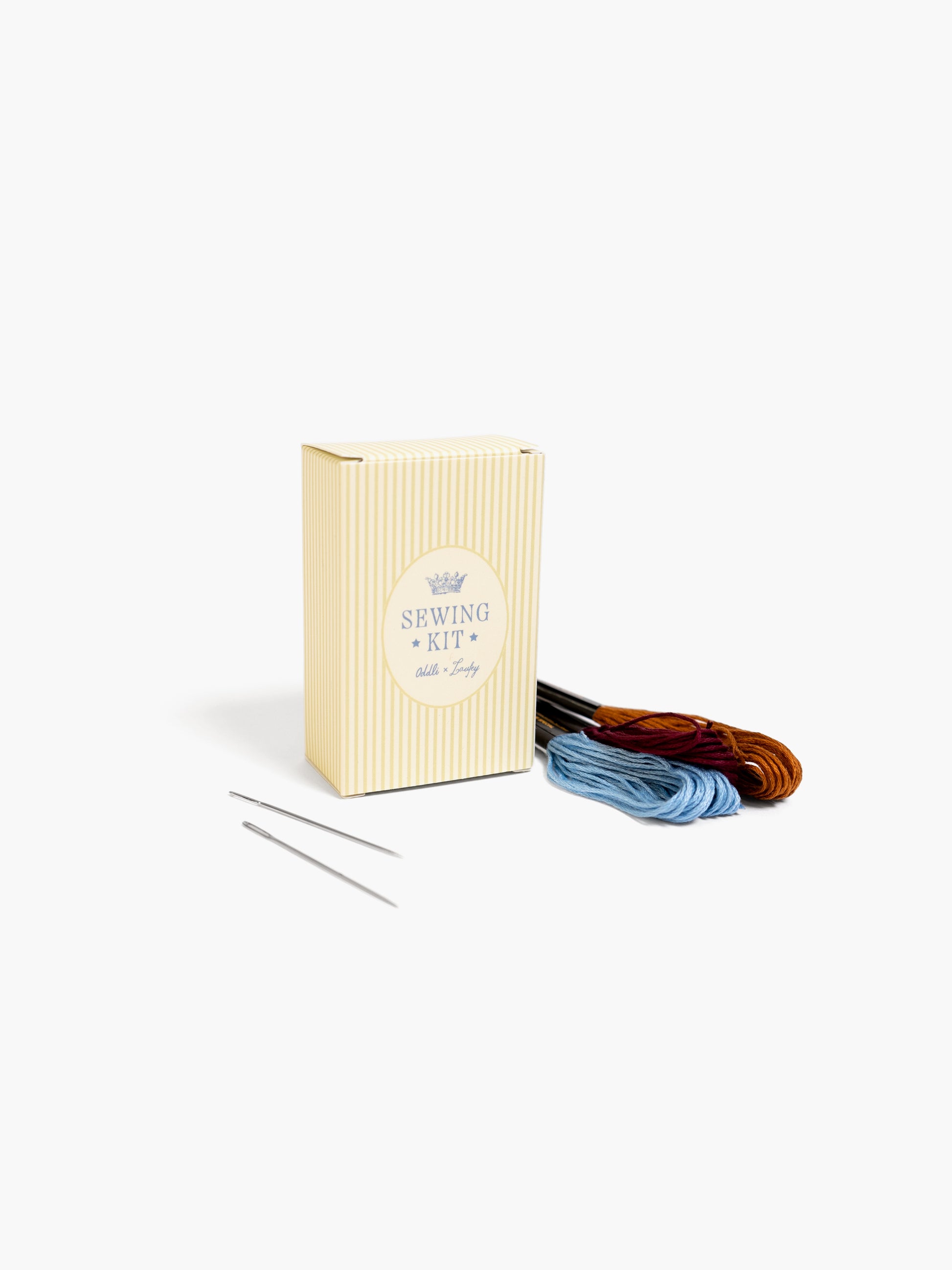 Sewing kit with thread and needles on a white background