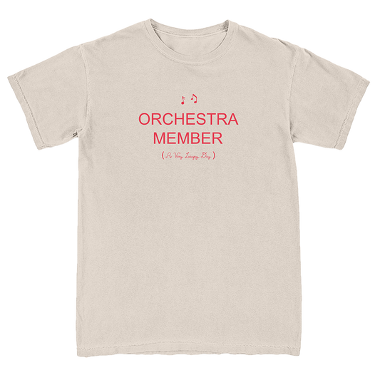 A light beige crewneck t-shirt with red printed text reading 'ORCHESTRA MEMBER (It's So Easyly Fun)' on the chest, displayed flat against a white background.