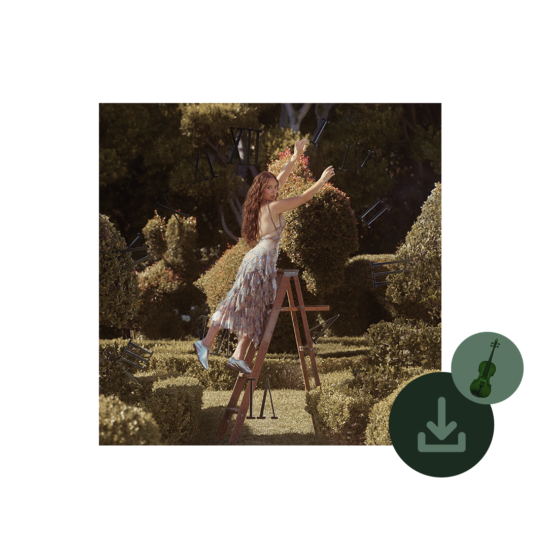 Woman Laufey on a ladder in a garden with a violin in the corner