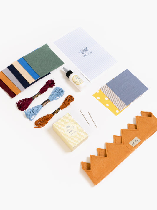 Collection of fabric swatches, thread, soap, and other sewing supplies on a white background
