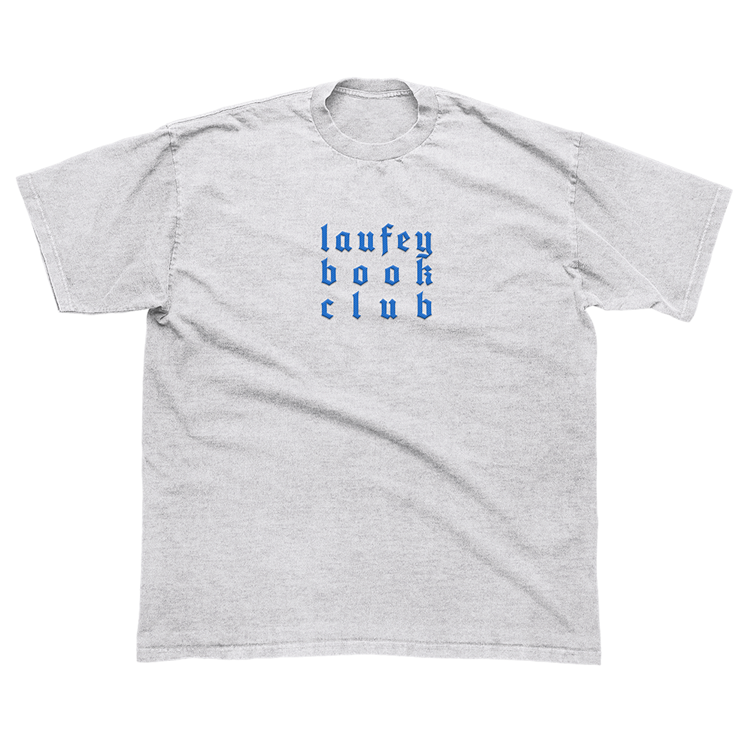 A light heather gray short-sleeve t-shirt with the words 'laufey book club' printed in blue gothic-style lettering on the chest, displayed flat against a white background.